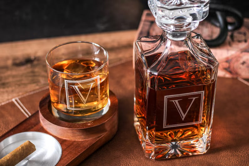 Whiskey decanter and glass with a brand logo on a wooden table