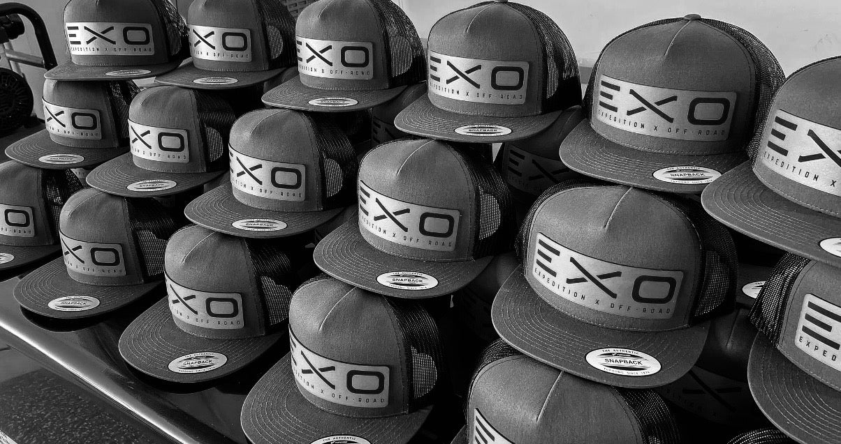 Stack of EXO branded hats in black and white.