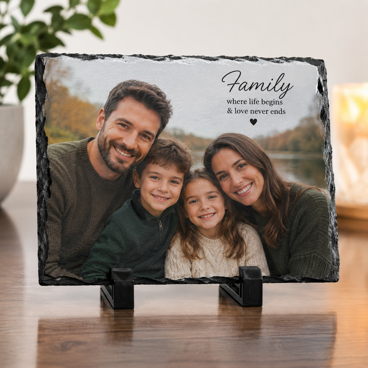 Slate photo plaque with a family photo and text on a wooden surface.