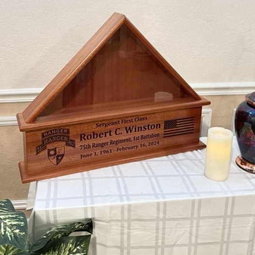 Wooden Flag case with engraved text on a table with a candle
