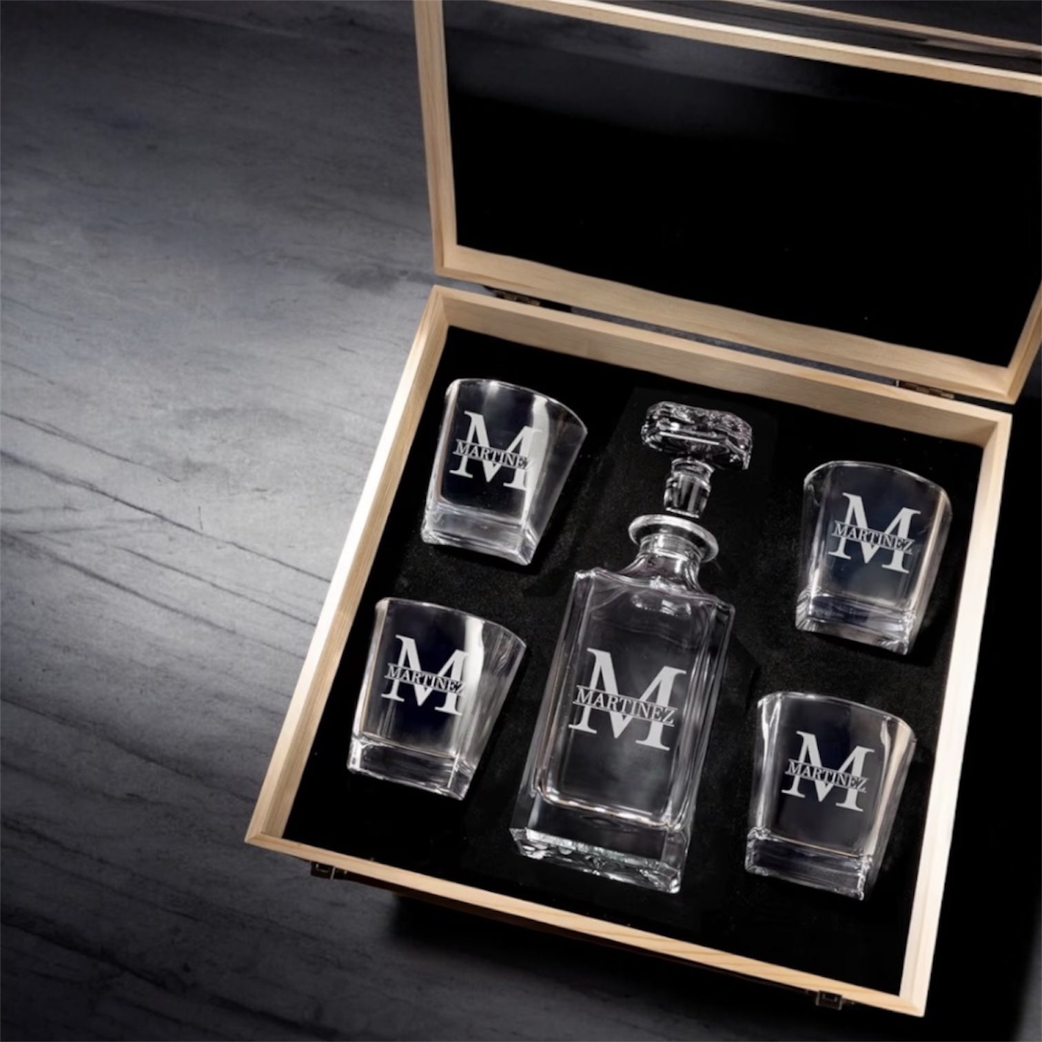 4 piece set of a glass decanter and glssses in a wooden box on a wooden surface.