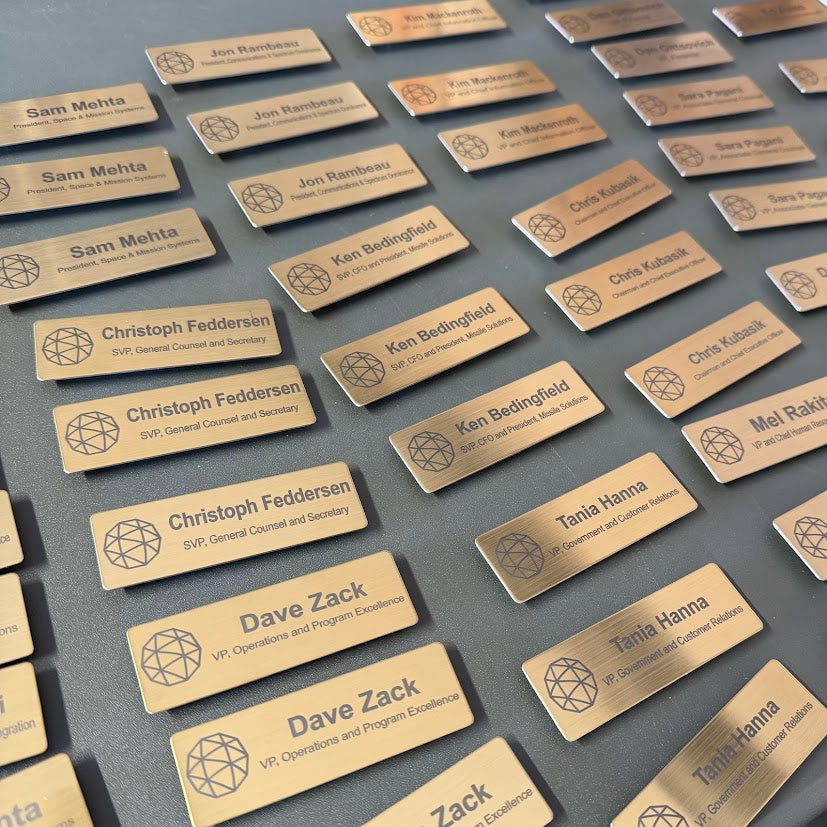 Engraved metal name tags by Engrave With Purpose, featuring customizable designs and clear engraved text for identification.